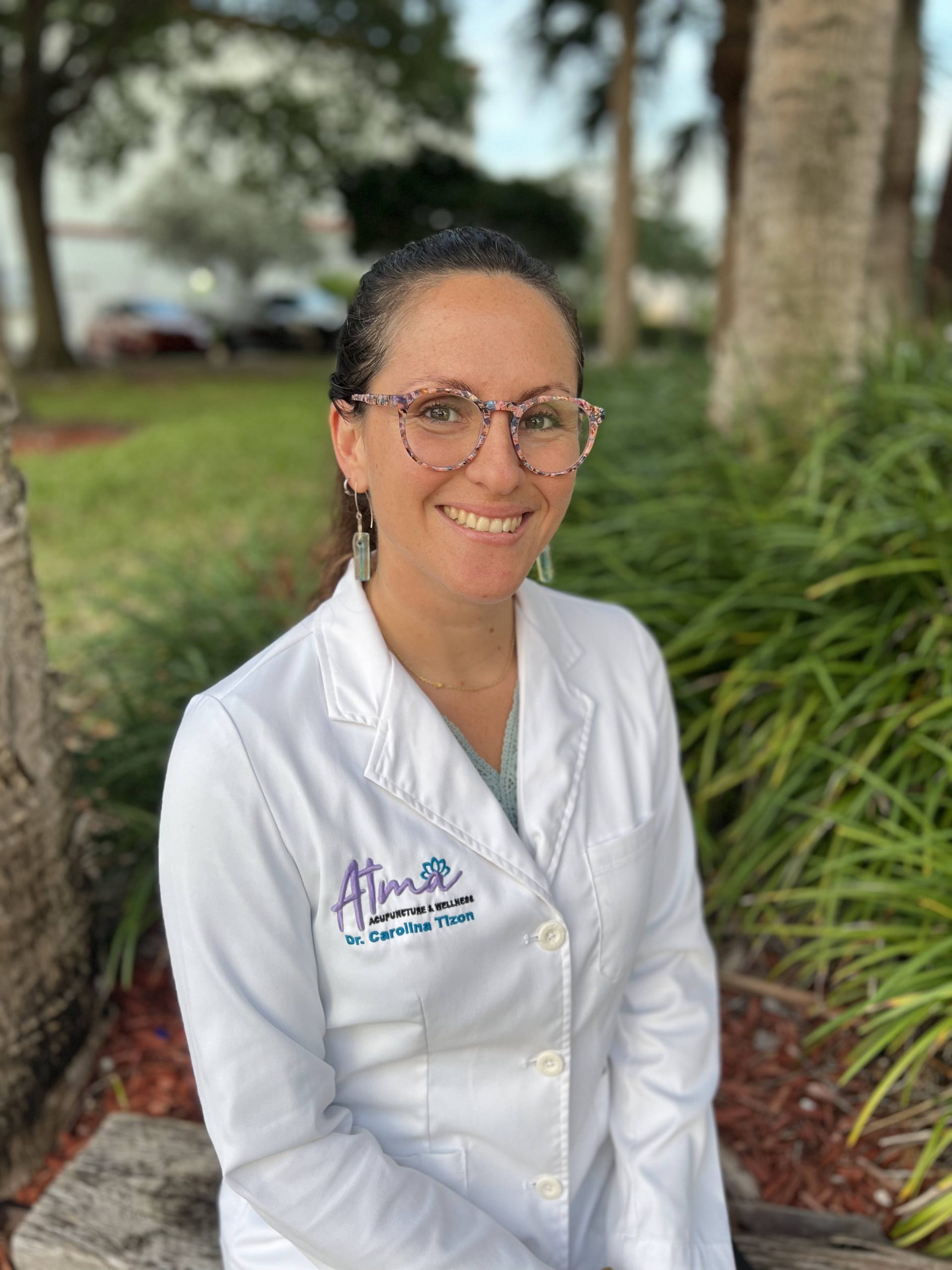 A woman in a lab coat practicing biomagnetic therapy on a bench. atma acupuncture