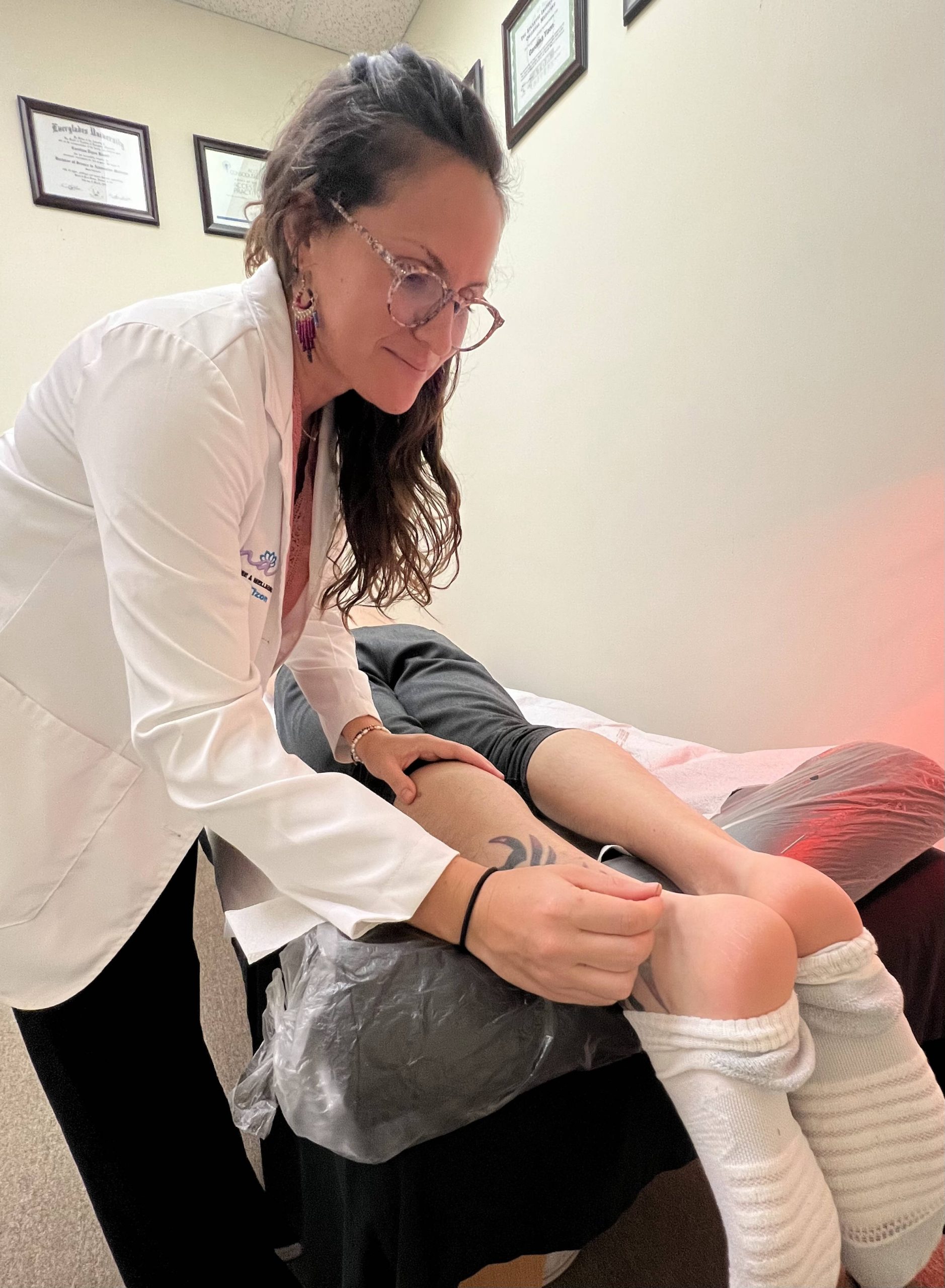 A woman receiving a foot massage during a holistic therapy session in a doctor's office. atma acupuncture