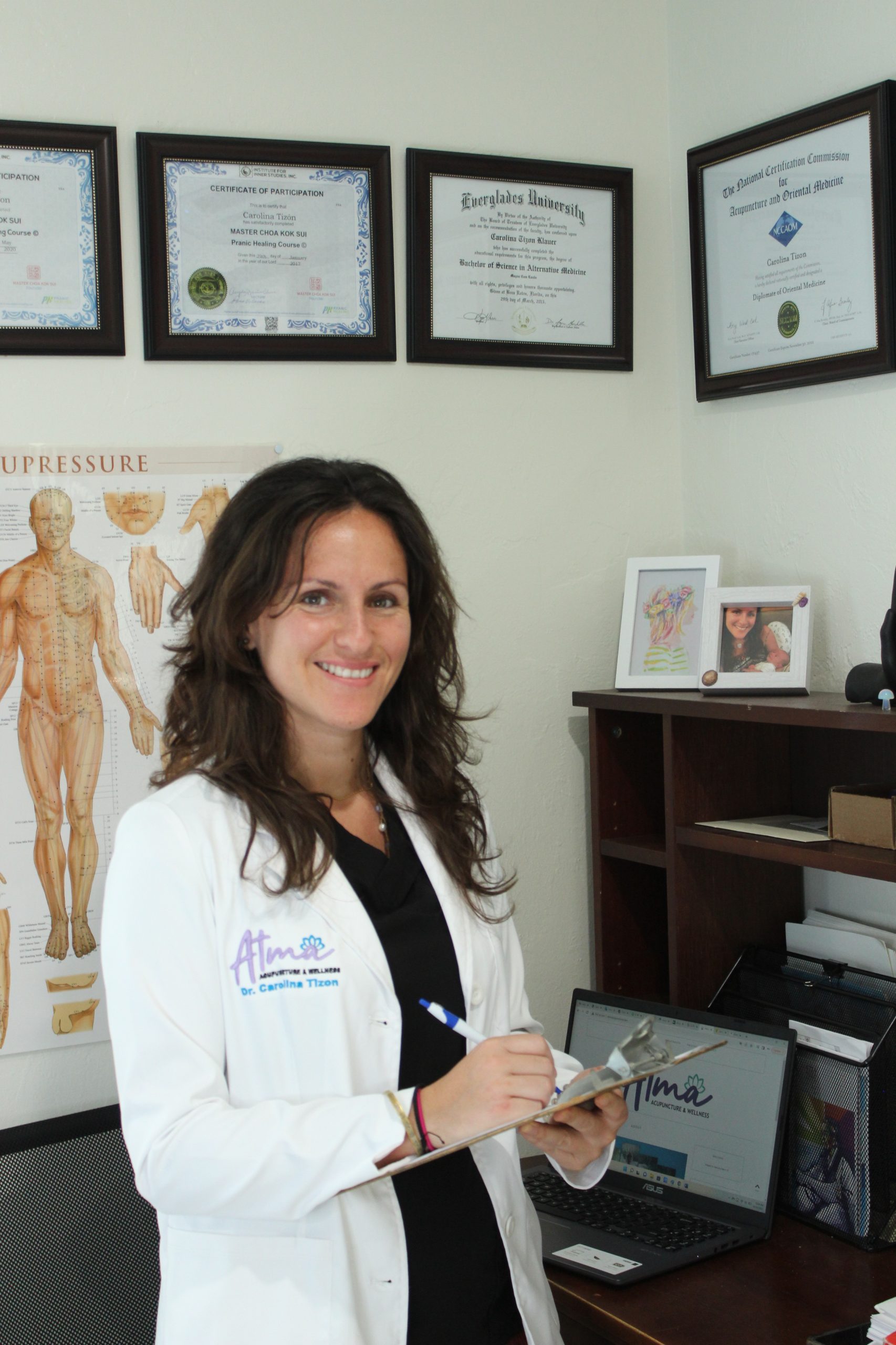 A woman wearing a white lab coat specializing in fertility treatments and holistic therapy Fort Lauderdale. atma acupuncture