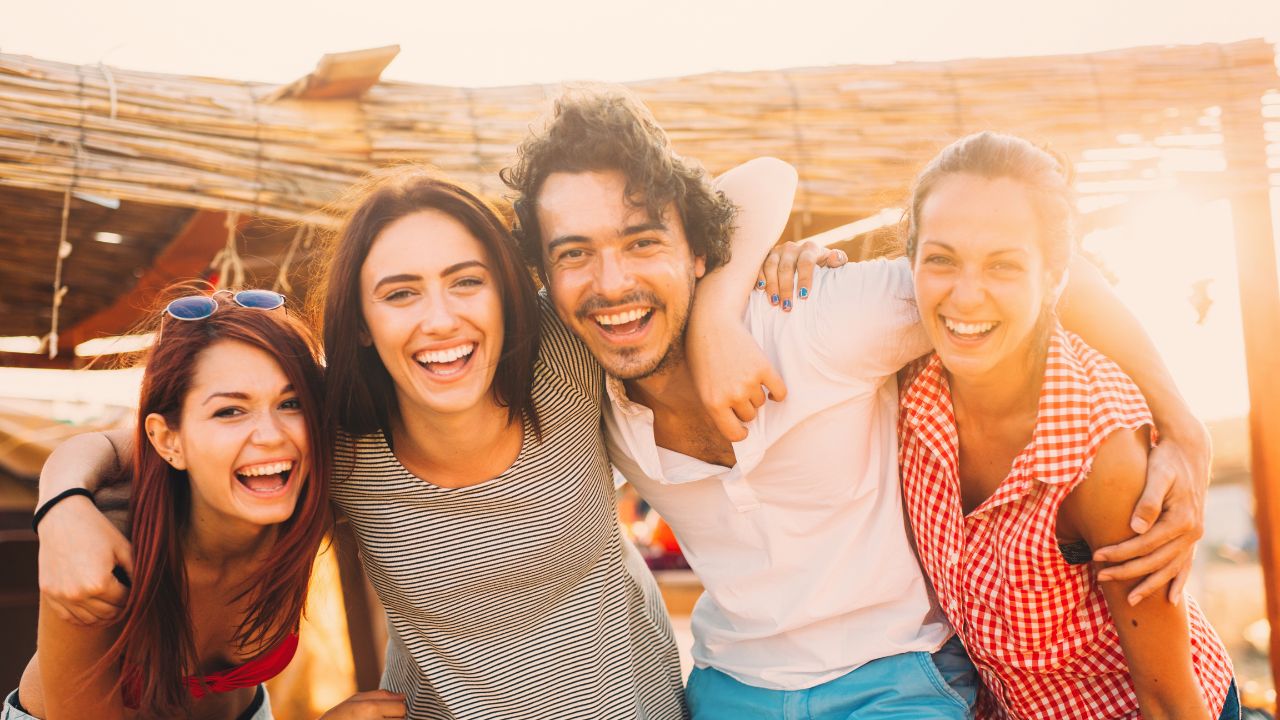 A group of friends enjoying holistic therapy together at the beach, laughing and having a great time. atma acupuncture