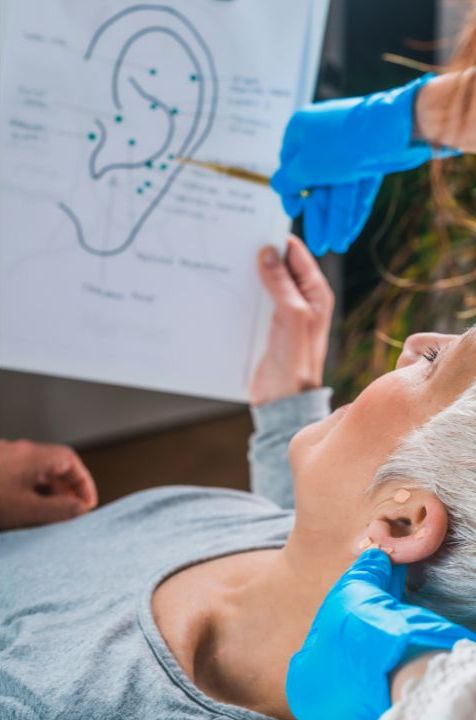 A woman is having her ear examined by an otolaryngologist in a holistic therapy session. atma acupuncture