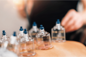 A woman is holding a bottle of liquid in front of a table, potentially using it for fertility treatments. atma acupuncture